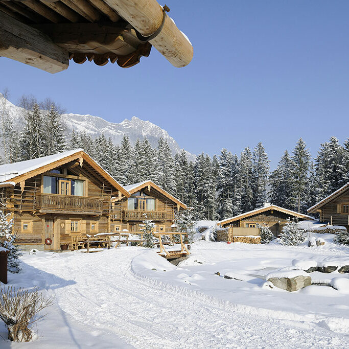 Bergdorf Priesteregg Dorfplatz- Huetten im Schnee