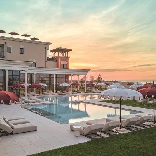 Golden-Hour-ueber-der-mediterranen-Poollandschaft-Cavallino-Bianco-Caorle-Venezia