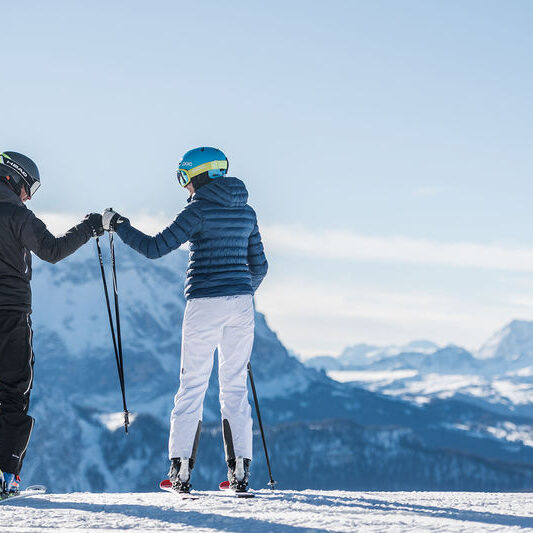 Skifahrer genießen das Bergpanorama am Kronplatz